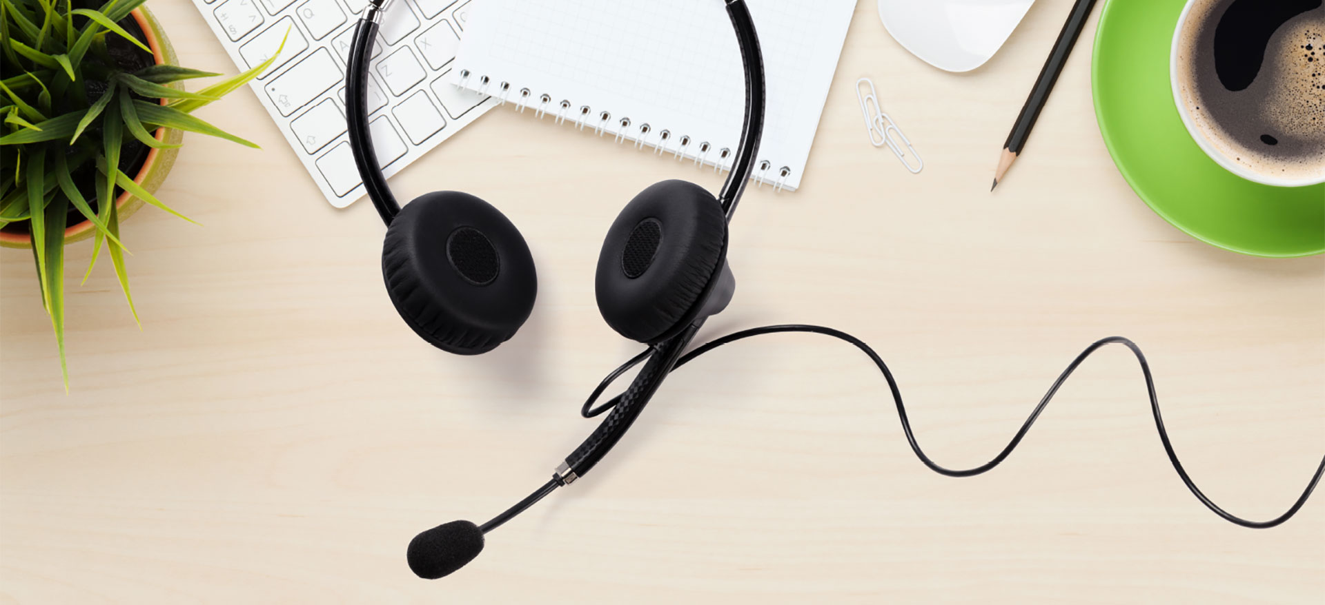 Workspace with headset, notebook and coffee